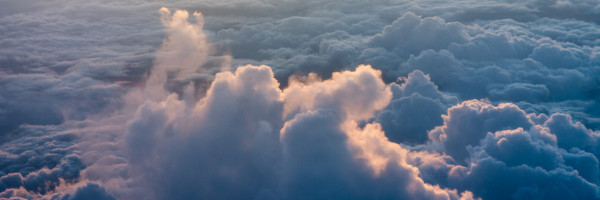 Blick von oben auf die Wolkendecke. Abendsonne am Horizont.