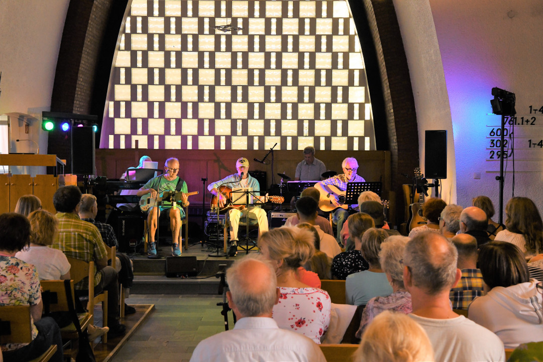 Die 5 Bandmitglieder der Band WESTCOAST sitzen mit ihren Instrumenten im Altarraum unserer Kirche