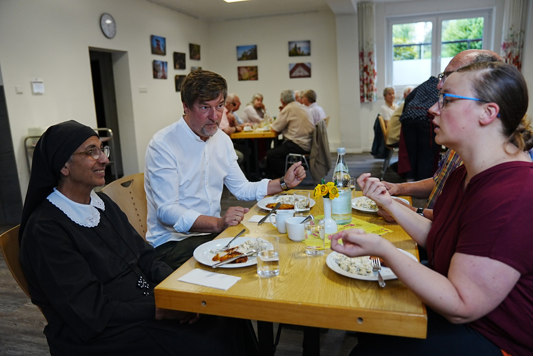 Schwester Demiana zusammen mit regionalen Kollegen sitzt an einem Tisch beim Scherpenberger Mittagstisch