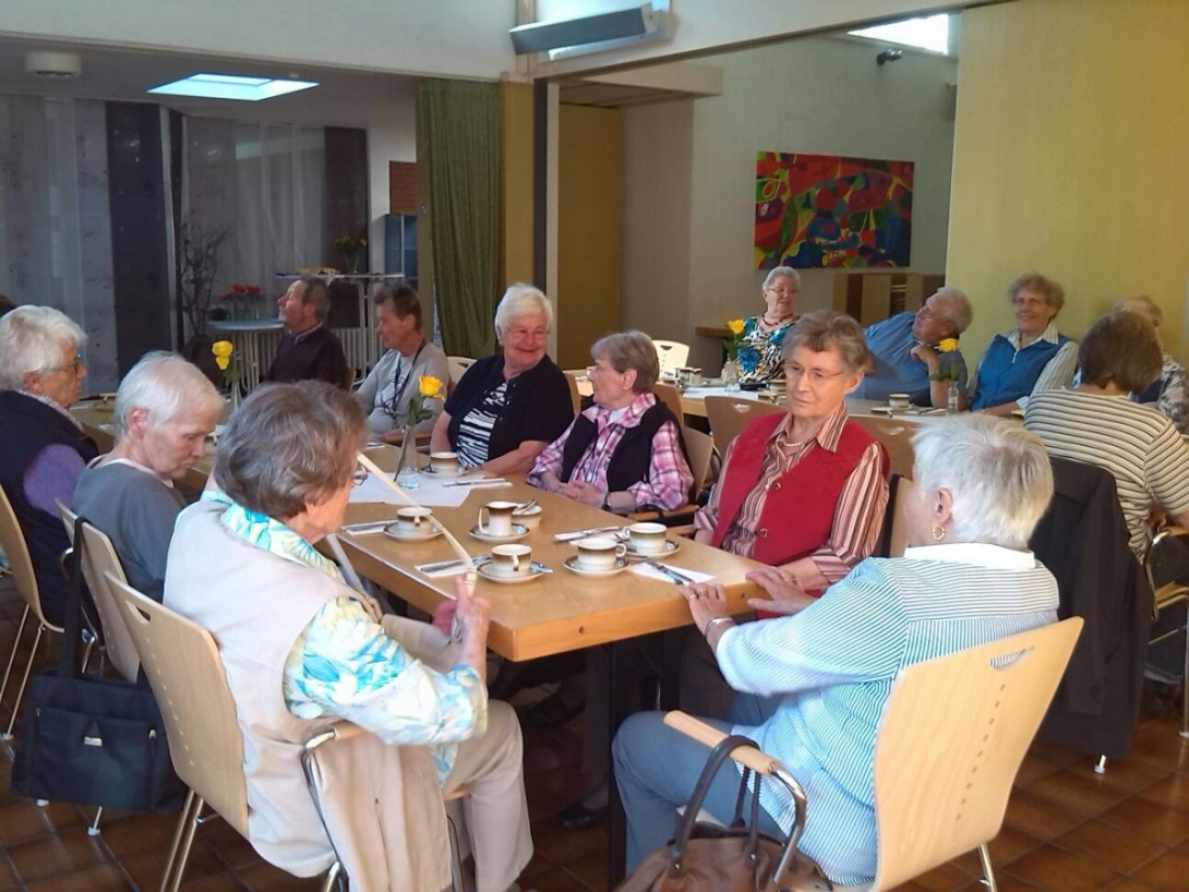Senioren mit Kaffee an Tischreihen