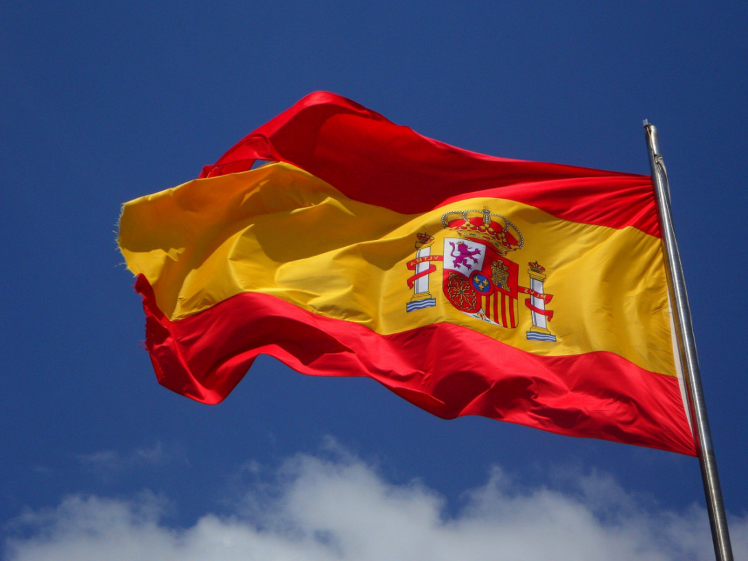 spanische Flagge vor blauem Himmel