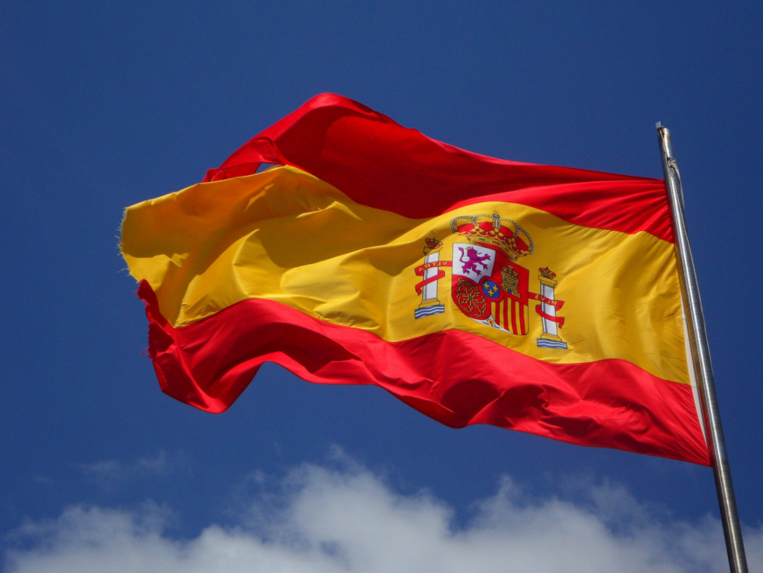 spanische Flagge vor blauem Himmel